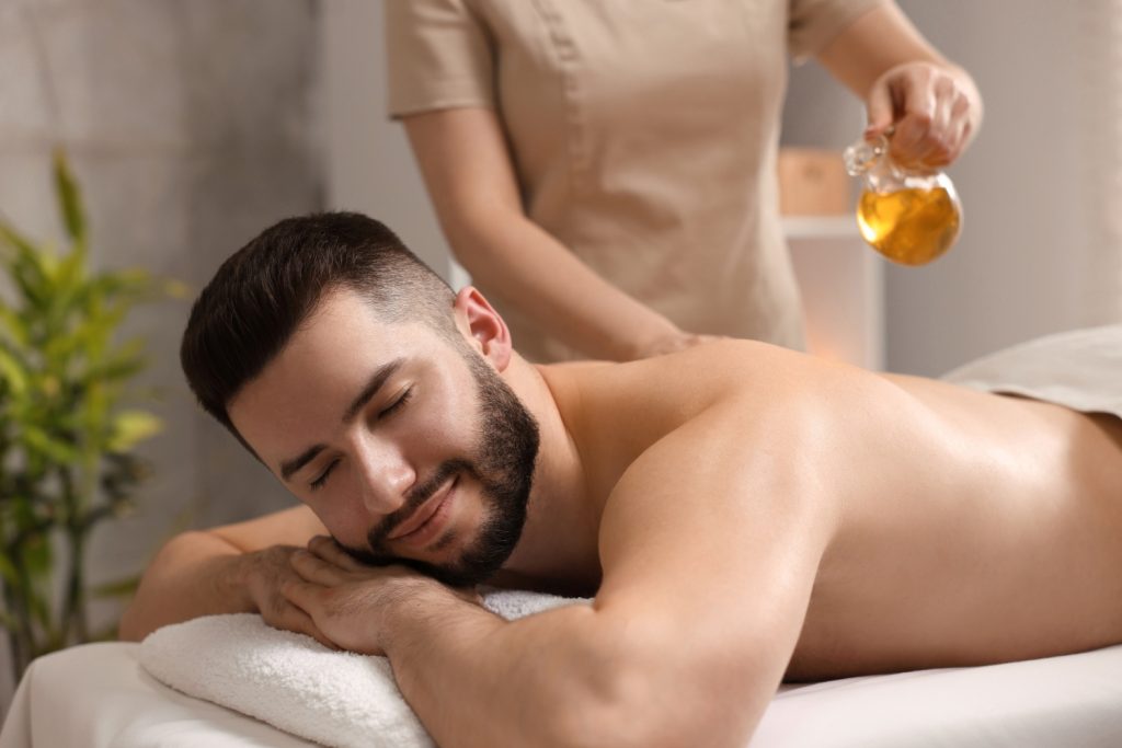 Ein junger Mann bei der Breußmassage mit Johanniskraut-Öl.